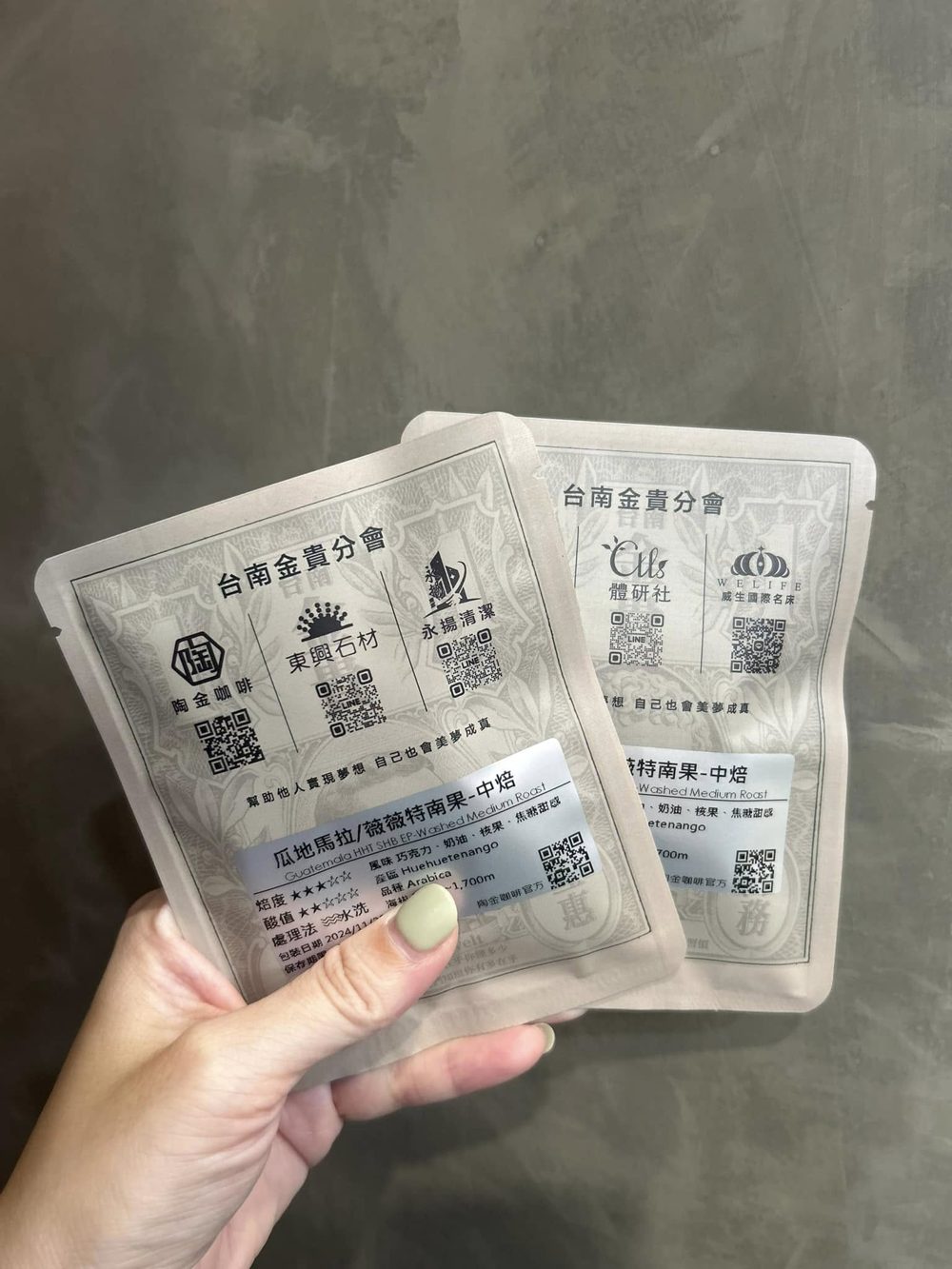 客製化濾掛咖啡背面，印著台南金貴分會與夥伴們的 logo、LINE QR code 和豆子標籤